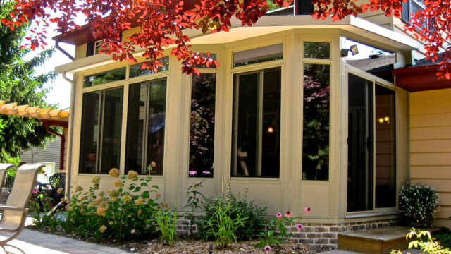 Bear Sunrooms backyard sunroom addition with large windows and garden landscaping